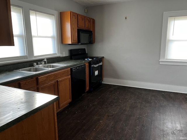 kitchen with dark wood-type flooring, black appliances, and sink