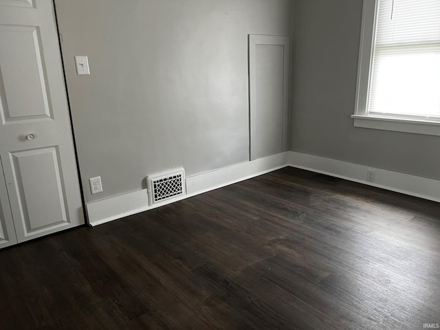 spare room with dark wood-type flooring