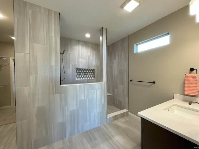 bathroom with vanity and a tile shower