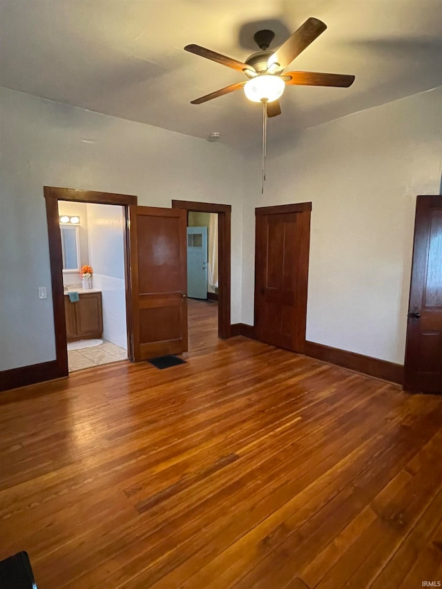 unfurnished bedroom featuring ceiling fan, light wood-type flooring, and ensuite bath