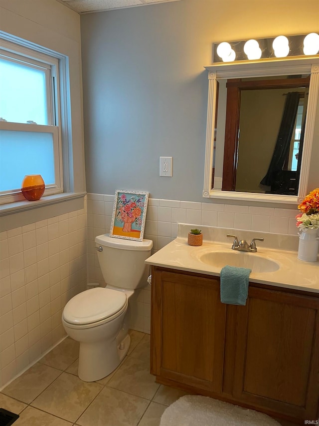 bathroom with tile patterned flooring, vanity, tile walls, and toilet