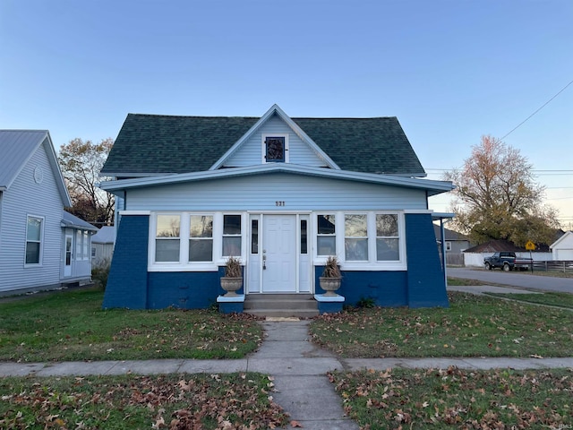 bungalow-style home with a front lawn