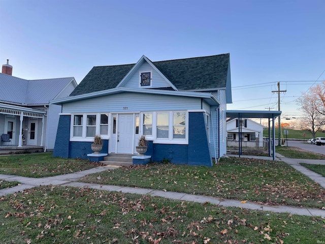 view of front of house featuring a carport and a front yard