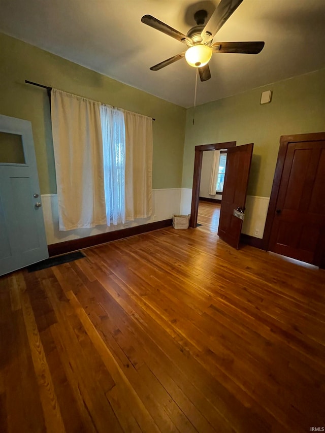 spare room featuring ceiling fan and dark wood-type flooring