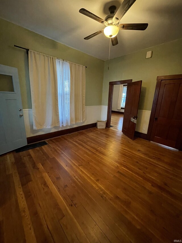 531 E 5th St, Mount Vernon, IN 47620 - empty room with dark wood-style floors, ceiling fan, and a wainscoted wall