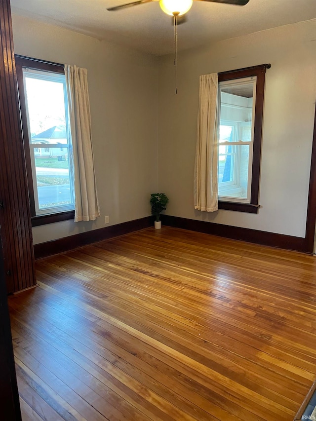 empty room with ceiling fan and hardwood / wood-style floors