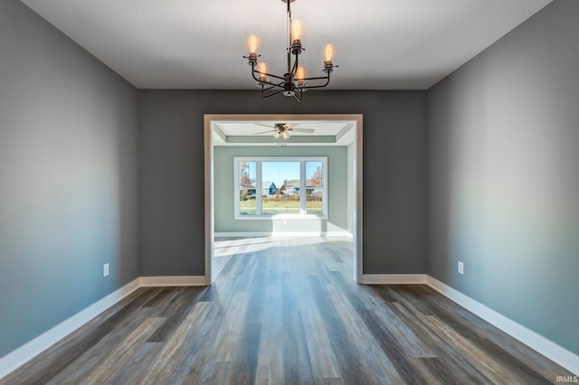 unfurnished dining area with dark hardwood / wood-style floors and ceiling fan with notable chandelier