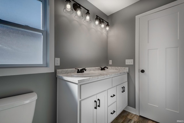 bathroom featuring plenty of natural light, vanity, hardwood / wood-style floors, and toilet