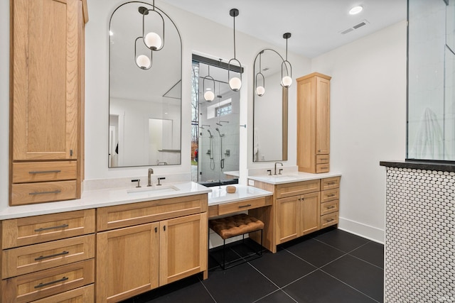 bathroom featuring tile patterned flooring, vanity, and a tile shower