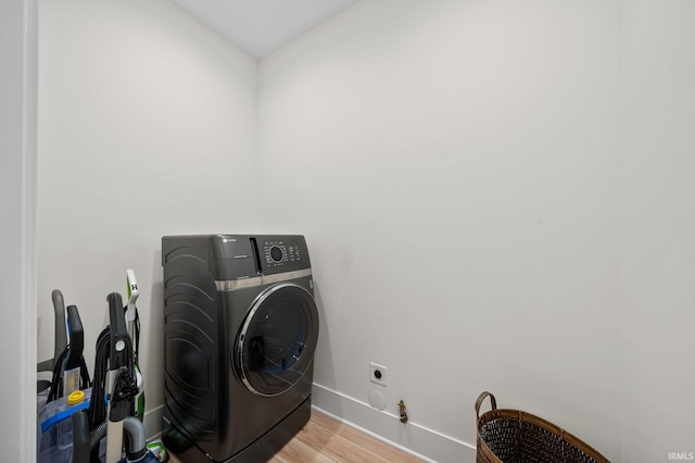 laundry room with washer / dryer and light wood-type flooring