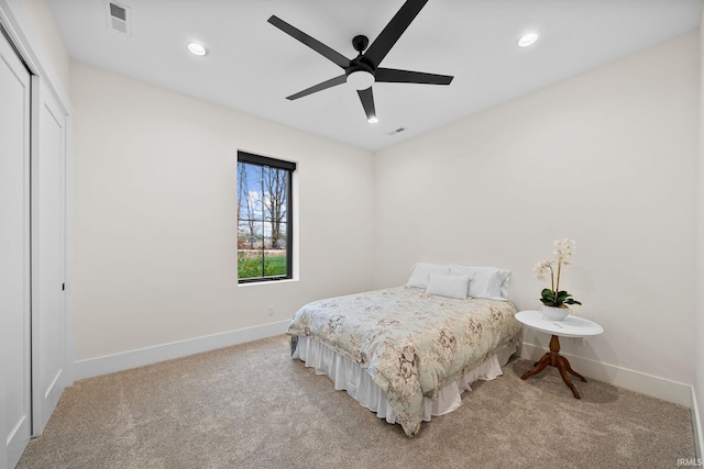 bedroom with a closet, light colored carpet, and ceiling fan