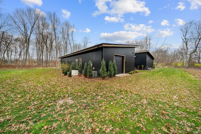 view of side of property with a garage, an outdoor structure, and a lawn