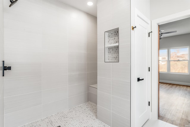 bathroom featuring a tile shower, ceiling fan, and hardwood / wood-style flooring