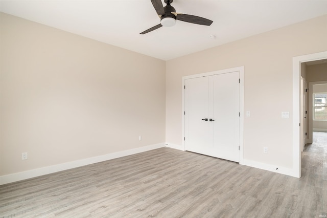 unfurnished bedroom with ceiling fan, light wood-type flooring, and a closet