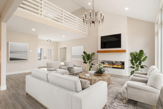 living room featuring a chandelier, hardwood / wood-style floors, and high vaulted ceiling