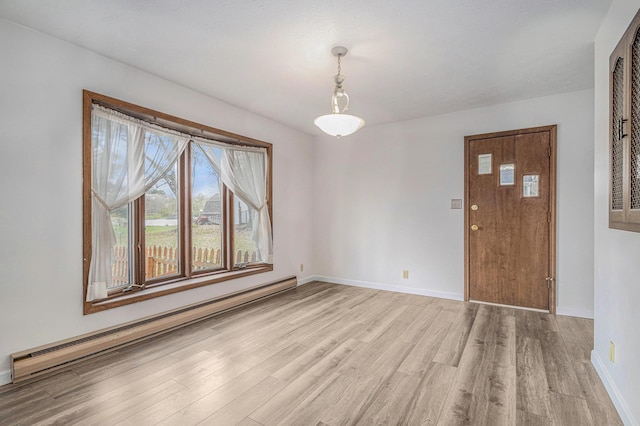 unfurnished dining area with baseboard heating and light hardwood / wood-style flooring