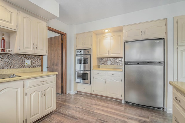 kitchen featuring backsplash, light wood-type flooring, and stainless steel appliances