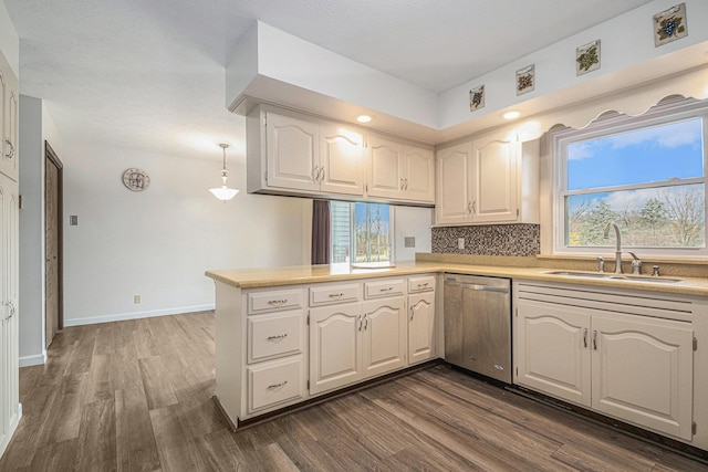 kitchen featuring dishwasher, sink, dark wood-type flooring, kitchen peninsula, and white cabinets