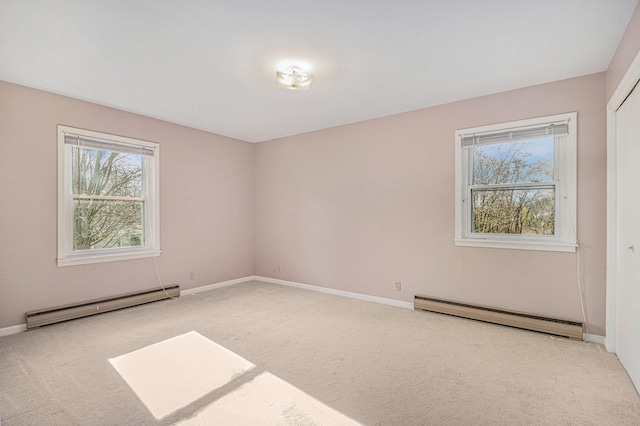 unfurnished room with light colored carpet and a baseboard heating unit