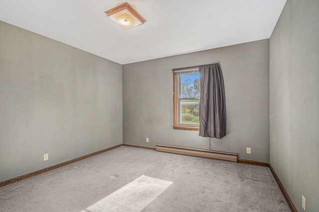 carpeted spare room featuring a baseboard heating unit