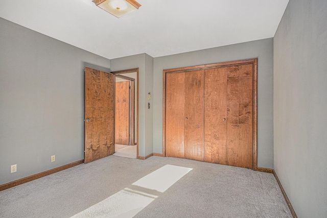 unfurnished bedroom featuring light carpet and a closet