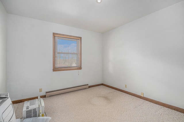 carpeted spare room featuring a baseboard heating unit