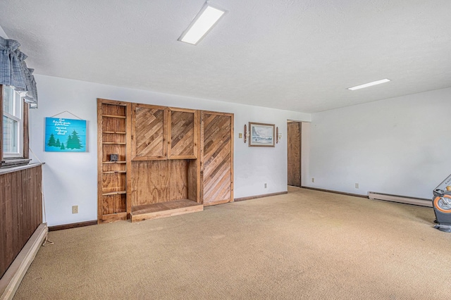 unfurnished living room featuring carpet floors, a textured ceiling, and a baseboard heating unit