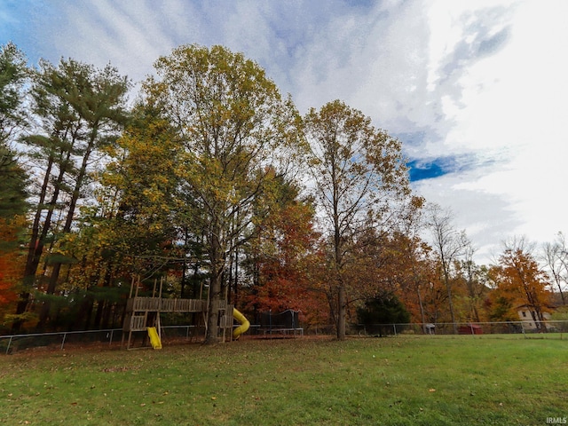 view of yard with a trampoline and a playground