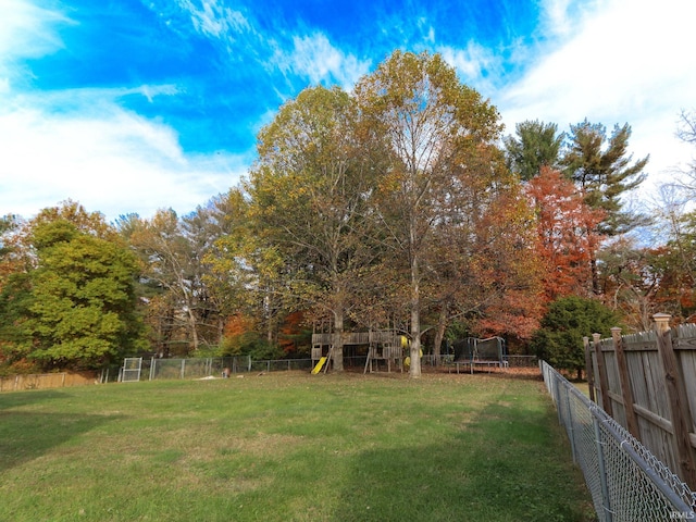 view of yard with a playground and a trampoline