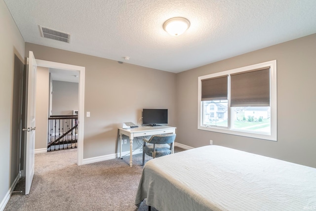 carpeted bedroom featuring a textured ceiling