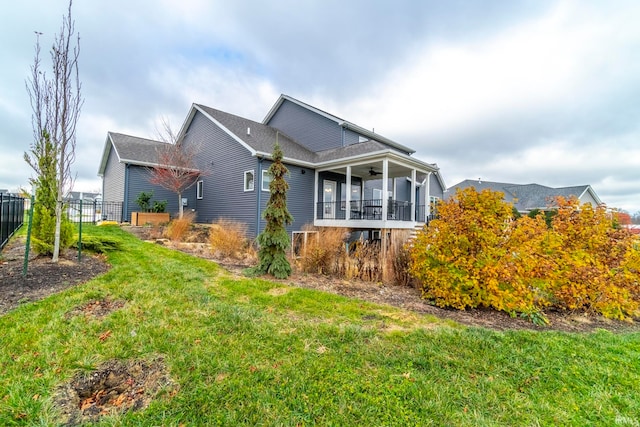 view of home's exterior featuring a sunroom, ceiling fan, and a lawn