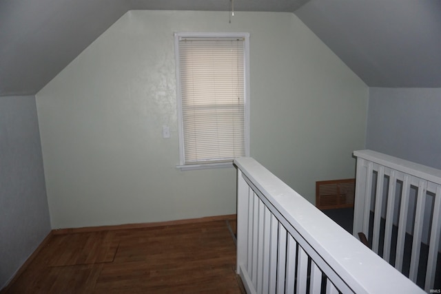 bonus room with dark hardwood / wood-style floors and vaulted ceiling