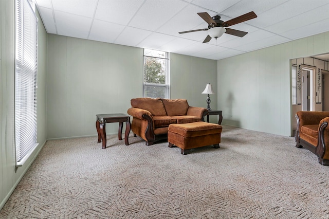 carpeted living room featuring a drop ceiling and ceiling fan