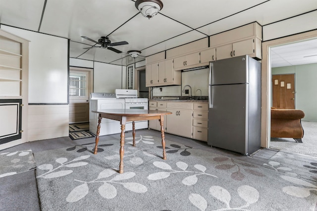 kitchen with light carpet, white range with gas cooktop, ceiling fan, independent washer and dryer, and stainless steel refrigerator