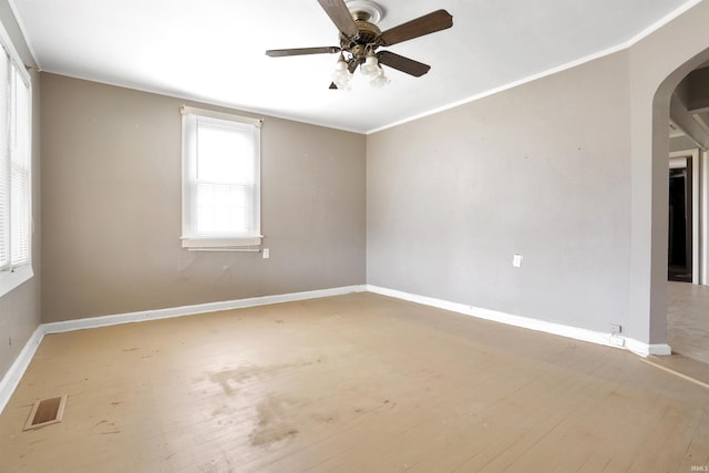 spare room featuring light wood-type flooring, ceiling fan, and ornamental molding