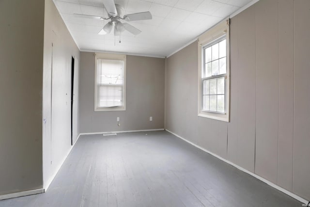 spare room featuring ceiling fan, a healthy amount of sunlight, and light hardwood / wood-style floors