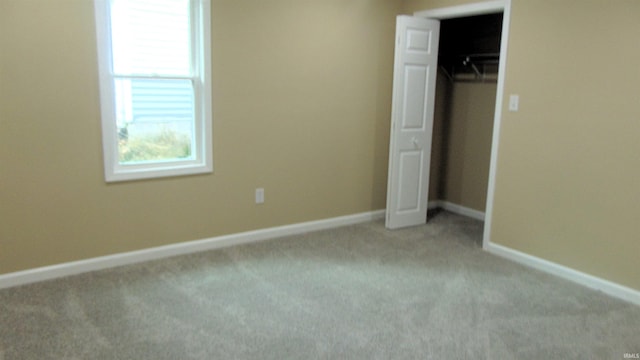 unfurnished bedroom featuring light carpet and a closet