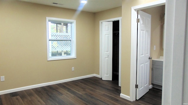 unfurnished bedroom with dark hardwood / wood-style flooring