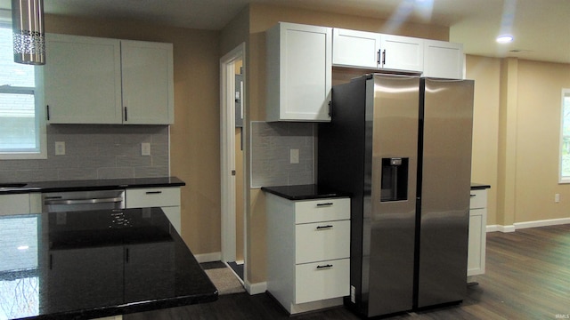 kitchen with tasteful backsplash, stainless steel appliances, white cabinetry, and dark hardwood / wood-style floors