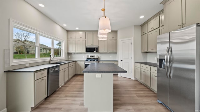 kitchen featuring sink, a center island, hanging light fixtures, stainless steel appliances, and light hardwood / wood-style floors