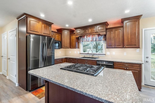 kitchen featuring light hardwood / wood-style floors, sink, stainless steel appliances, and a kitchen island