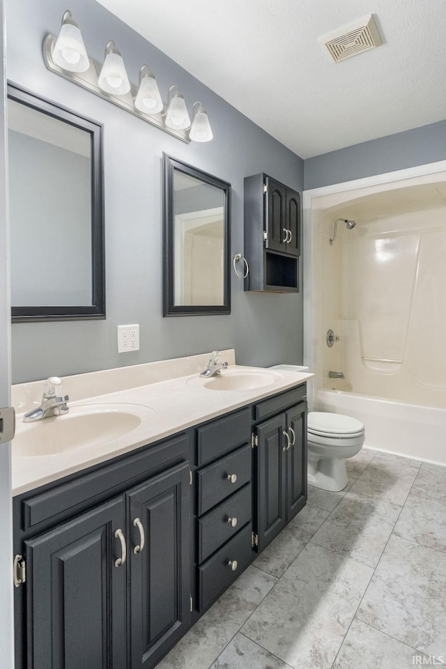 full bathroom featuring vanity,  shower combination, toilet, and a textured ceiling