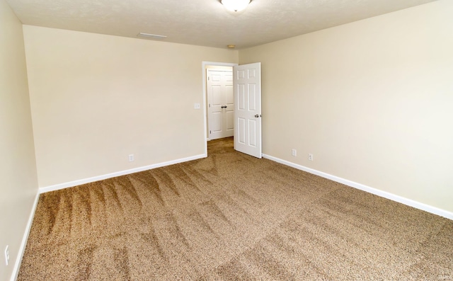 empty room featuring carpet floors and a textured ceiling