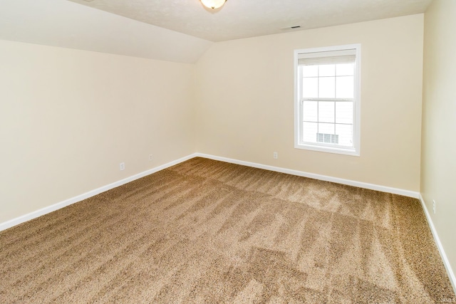 empty room with carpet floors and lofted ceiling