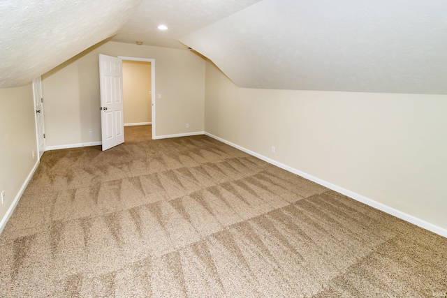 bonus room with carpet flooring, a textured ceiling, and lofted ceiling