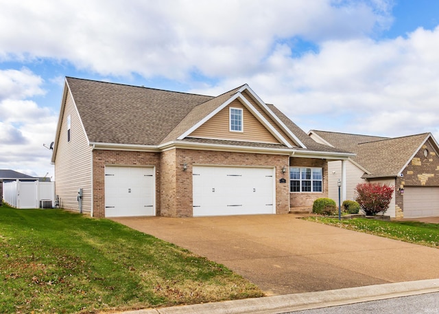 craftsman-style home featuring central AC unit, a garage, and a front lawn