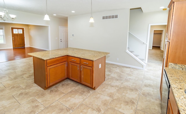 kitchen featuring light stone countertops, an inviting chandelier, and hanging light fixtures