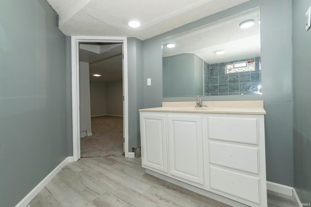 bathroom with hardwood / wood-style floors, vanity, and a textured ceiling