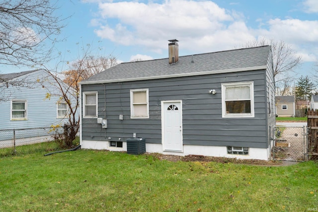 back of house with central AC and a lawn