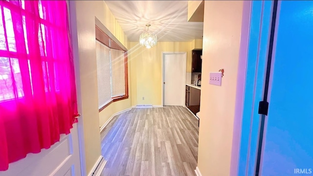 hallway with a chandelier and wood-type flooring